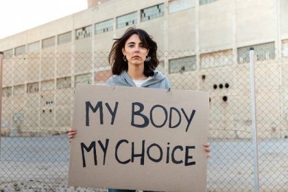 mladá kavkazská žena se dívá na kameru s vážným výrazem držícím kartonový nápis: moje tělo moje volba - podpor interrupcí - stock snímky, obrázky a fotky