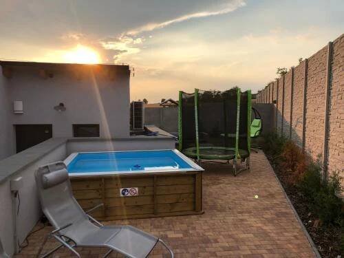a hot tub sitting on a patio with a chair at Apartmány Přítluky in Přítluky