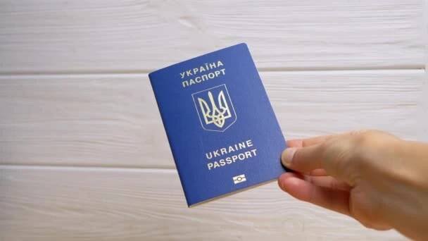 Žena Ruka drží modrý biometrický pas Ukrajiny na bílém pozadí. Inscription in Ukrainian Ukraine Passport. Dívka ukazuje obdržené mezinárodní doklad pro cestování do zahraničí, cestování. — Stock záběr