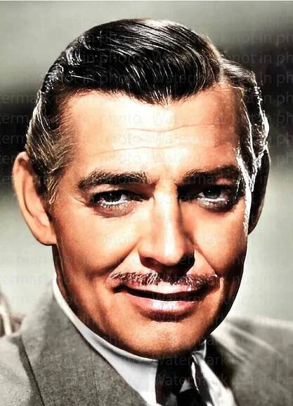 Clark Gable in a suit and tie is smiling for the camera
