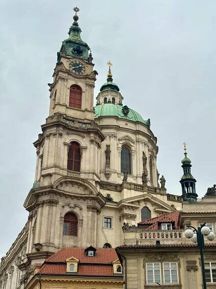 bezplatná Úchvatný pohled na kostel sv. Mikuláše s barokní architekturou pod zataženou oblohou. Základová fotografie