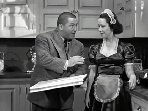Curly trying to make time with the maid in the kitchen