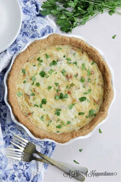 A quiche Lorraine on a blue and white kitchen towel.