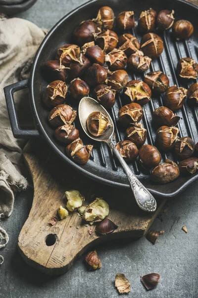 chestnuts being cooked in a cast iron skillet