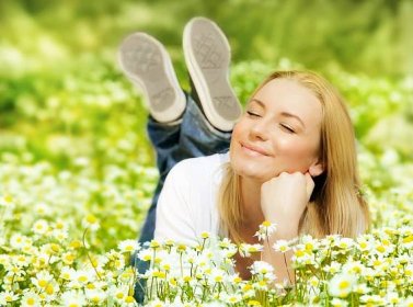 Stáhnout - Krásná žena líbí daisy pole, pěkná žena vleže v lučních květin, hezká dívka relaxační venkovní, zábavu, šťastná mladá dáma a jarní zelené přírody, harmonie a svobody koncepce — Stock obrázek