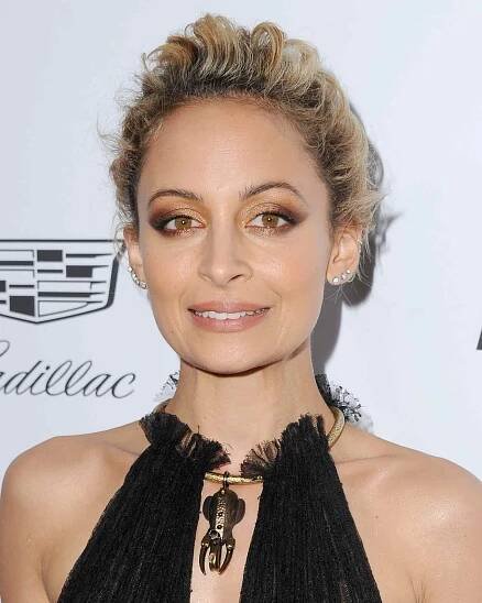 Nicole Richie wears a feathered, curly pixie cut with a black halter top dress