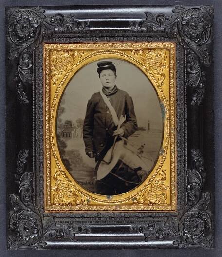[Young George Wingate Weeks of Company D, 8th Maine Infantry Regiment with drum in front of painted backdrop showing shoreline with house and lighthouse]