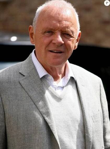 an older man wearing a gray suit and white shirt is looking off to the side