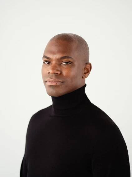 Headshot of Jonathan Carver Moore wearing a black turtleneck 