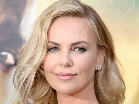 Charlize Theron is a vision in silk dress and statement necklace for rare appearance