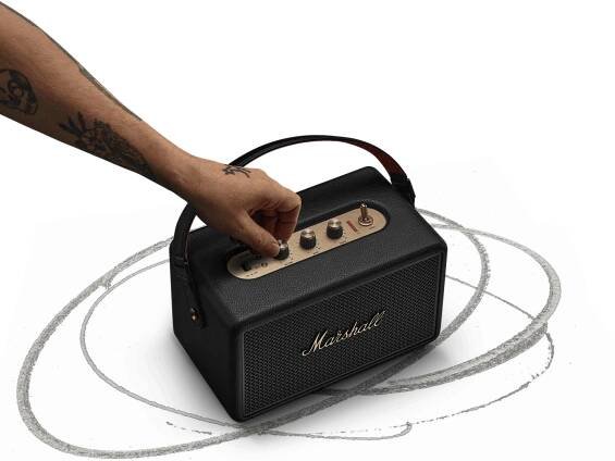 Adjusting the control knob on the Marshall Kilburn III Black and Brass portable speaker.