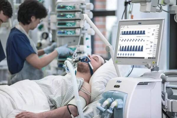 Zdravotní sestra kontroluje plicní ventilátor pacienta na JIP