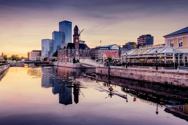 A person canoing in the canal in Malmö in the sunrise.
