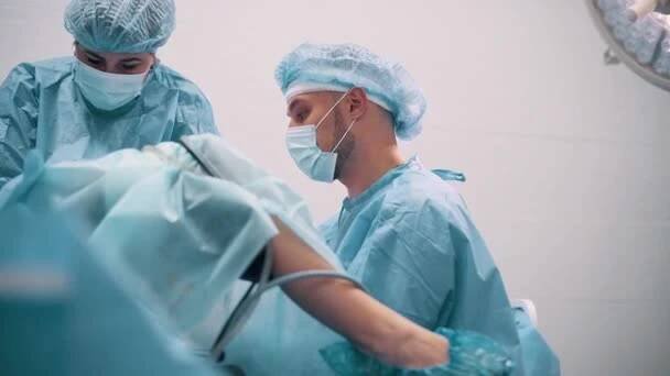 Lékař provádí gynekologickou operaci pomocí speciálního vybavení. Chirurg sleduje obrazovku. — Stock záběr