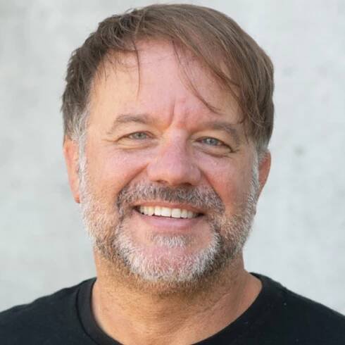 Todd with short brown hair and beard, smiling, wearing a black shirt







