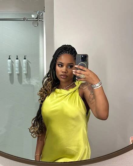 Ashley Jones taking a selfie in a yellow dress.