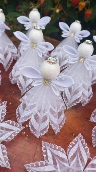 some white angel ornaments sitting on top of a wooden table