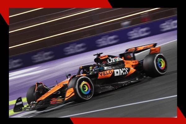 Racer Oscar Piastri's car speeds by on a track.