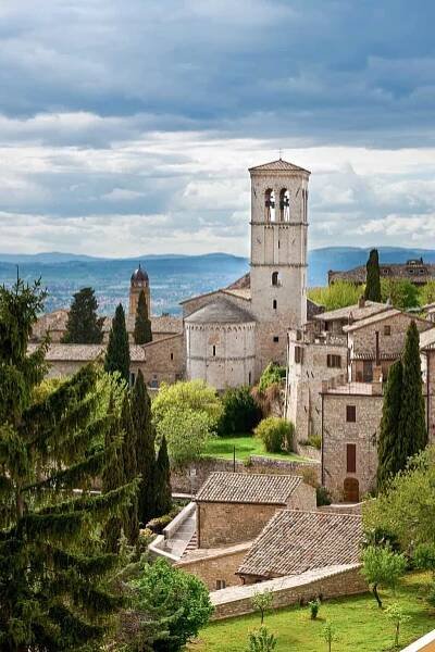 Church of Assisi on a sunny day surrounded by countryside. 