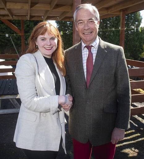Nigel Farage shaking hands with a woman.