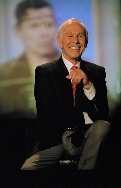 Johnny Carson smiles on stage.