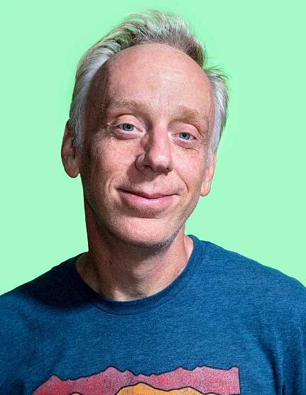 Actor Mike White against a green backdrop.