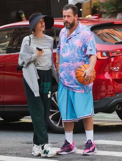  Adam Sandler and wife Jackie Sandler share a kiss in New York City. The 58 year old American actor was on his way to play basketball wearing a Hawaiian shirt paired with teal shorts took some time to embrace his significant other before hitting the courts.