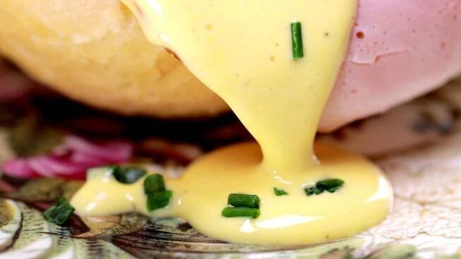 a yellow sauce being poured onto some food