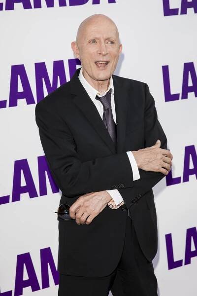 Richard O'Brien in a black suit.