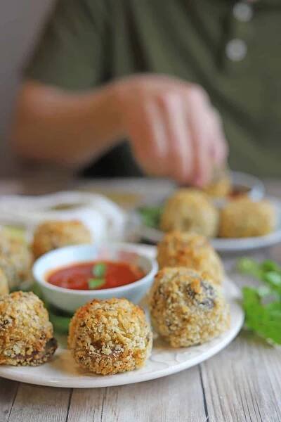 Crispy arancini balls on plate with marinara.