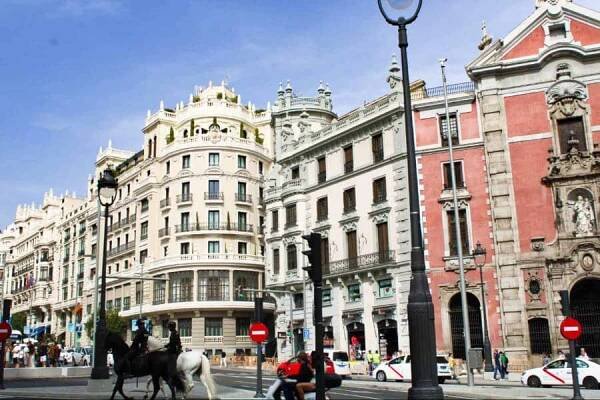 View of the busy street and architectural buildings of Calle Gran Vía in Madrid
