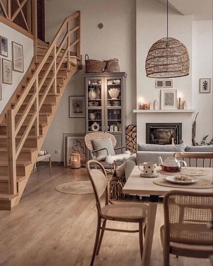 a living room filled with furniture and a fire place next to a stair case in front of a fireplace
