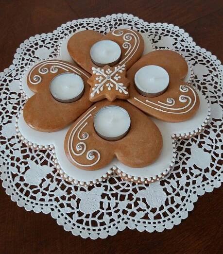 some cookies on a doily with candles in them