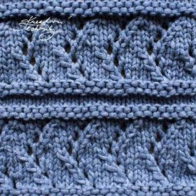 a blue knitted blanket with holes in the middle and two rows of stitches at the bottom