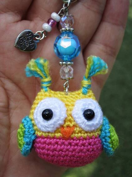 a crocheted owl keychain hanging from a person's hand
