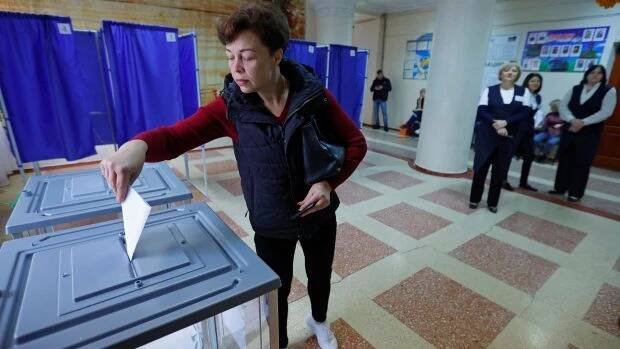 Žena vhazuje svůj hlas během světem neuznávaného referenda v Ruskem okupovaném Doněcku