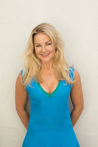 a woman in a blue dress is smiling for the camera