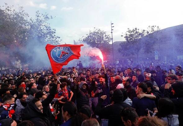 Paris Saint-Germain fans celebrating with flares and flags.