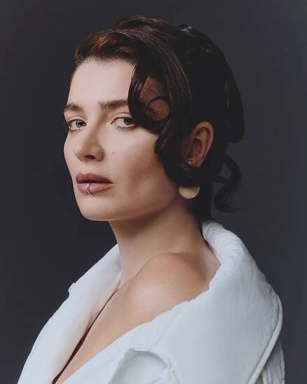 Eve Hewson wearing a lip ring and white puffy coat.