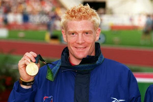 Athlete holding a gold medal.