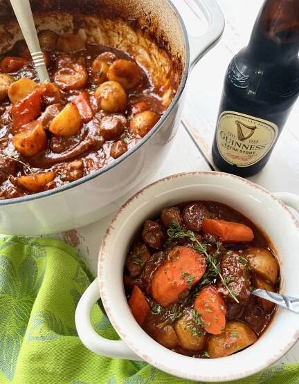 bowl of Irish stew with a bottle of Guinness beer.