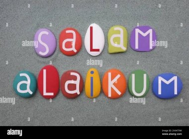 Salam Alaikum standard salutation among members of the Nation of Islam composed with hand painted multi colored stone letters over green sand Stock Photo