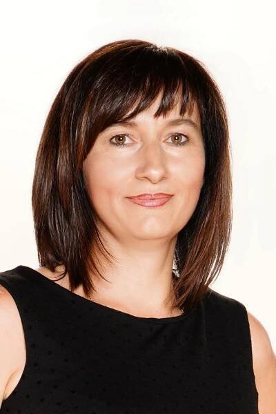 a woman in a black top is smiling at the camera