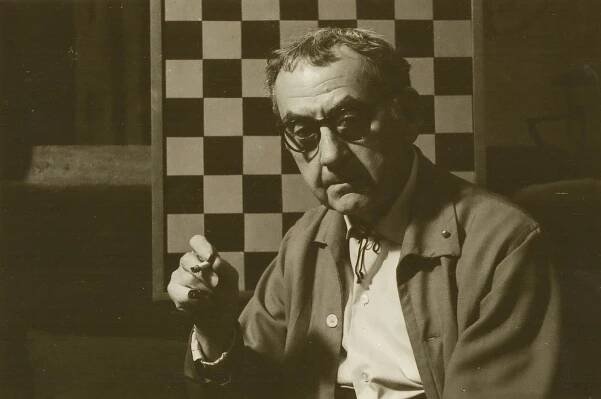 Portrait of photographer Man Ray against his chess board