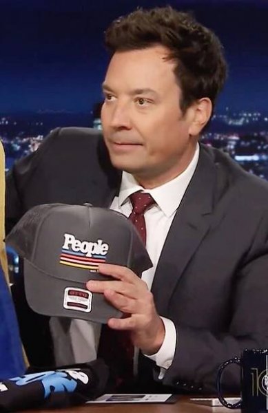 Jimmy Fallon holds up a People Magazine branded hat