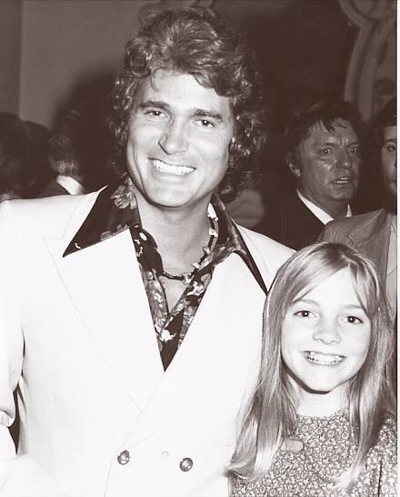 Michael Landon and Alison Arngrim smile for a photo, with Michael wearing a suit and Alison in a patterned dress