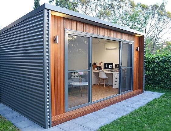 a small backyard office with sliding glass doors