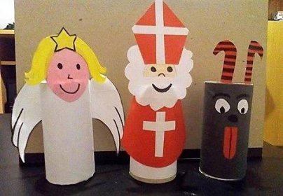 three paper dolls are lined up on a table next to each other, one is wearing a crown and the other has an angel