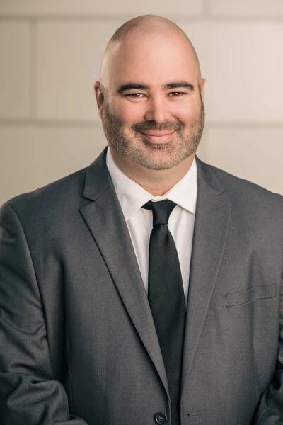 bald man with beard in a gray suit 