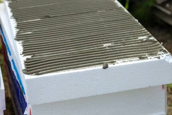 Insulation of facade wall with styrofoam sheets. Polystyrene insulation boards with glue adhesive